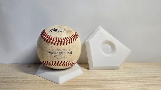 Bal Display in vorm van een baseball plaat Oude baseball, naast een witte honkbalplaat.