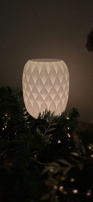 Een zwaaiende witte lamp in een decoratieve omgeving met groen en lichtjes.